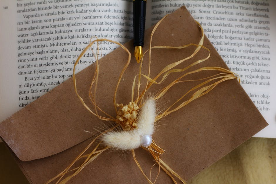 Brown envelope adorned with natural elements and a fountain pen on open book, ideal for rustic stationery themes.