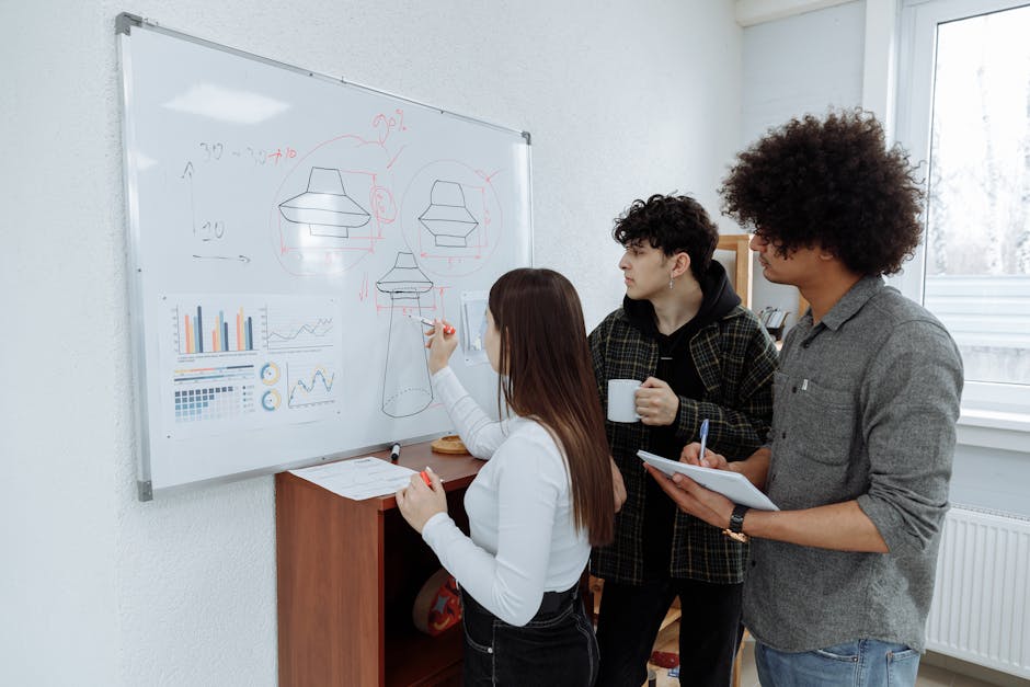 Young professionals brainstorming and designing a product prototype on a whiteboard.